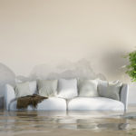 white couch partially submerged in water in a nice living room